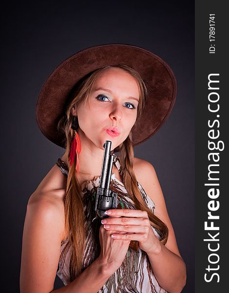 The American Indian girl in a cowboy's hat holds a pistol