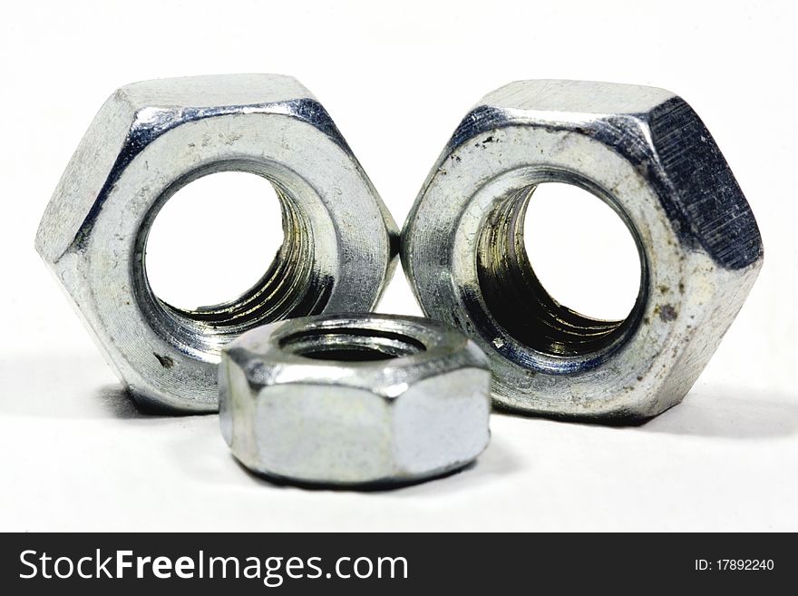 Steel nuts up close on a white background