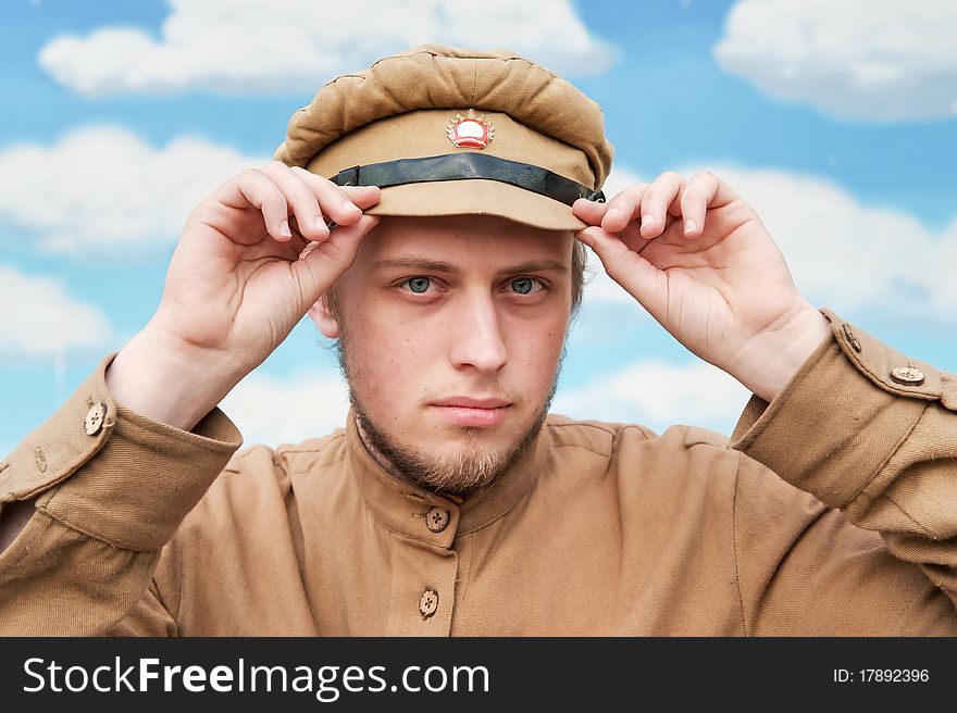 Portrait of soldier in uniform of World War 1 on the background of blue sky. Costume accord the times of World War I. Photo made at cinema city Cinevilla in Latvia. Cockade on the hat do not contain trade mark. Portrait of soldier in uniform of World War 1 on the background of blue sky. Costume accord the times of World War I. Photo made at cinema city Cinevilla in Latvia. Cockade on the hat do not contain trade mark.