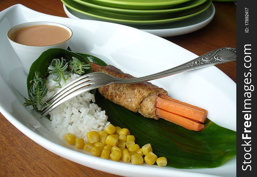 Dish with meat roll,rice and corn