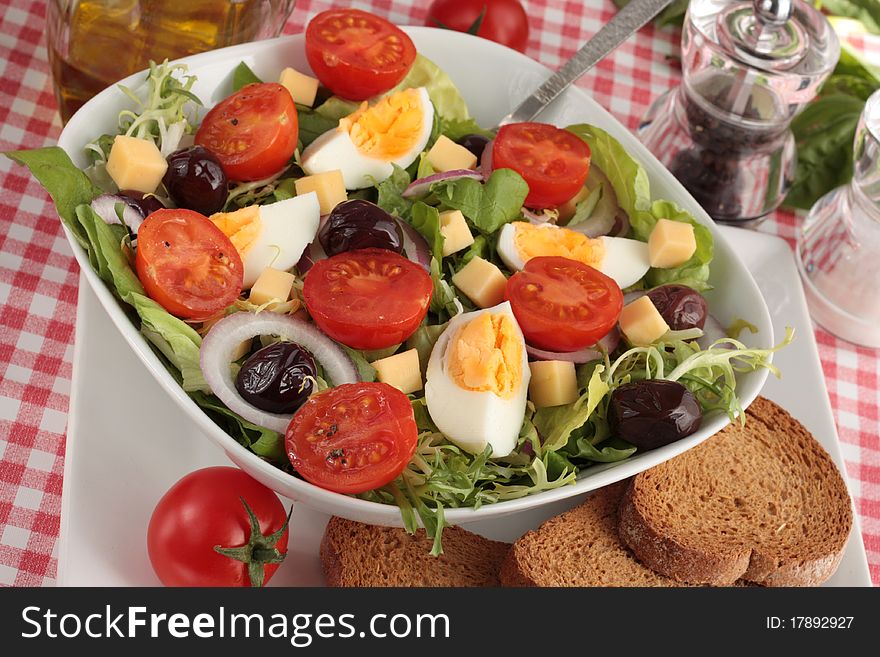 A simple, fresh salad of lettuce, tomatoes, egg, black olives, onions and cheese. Served with wholemeal bread.