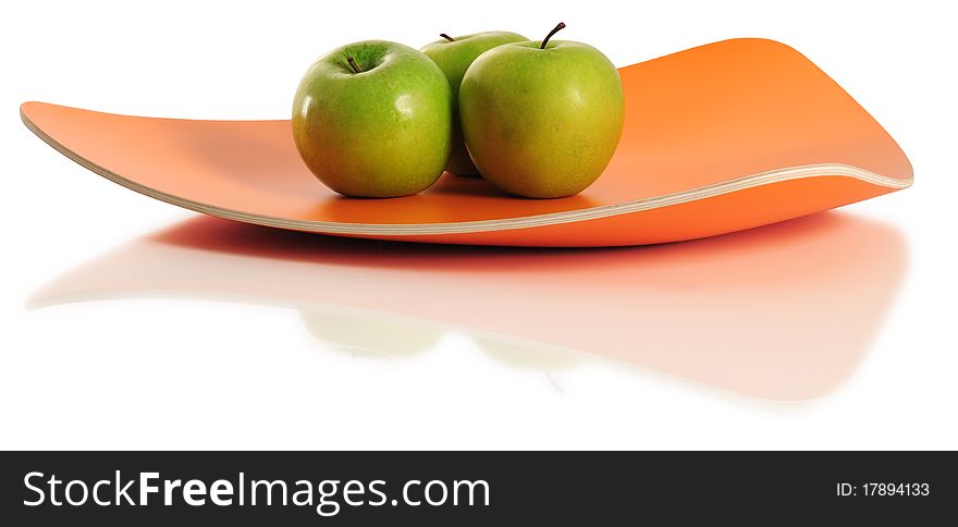 Three green apples on an orange tray. Three green apples on an orange tray.