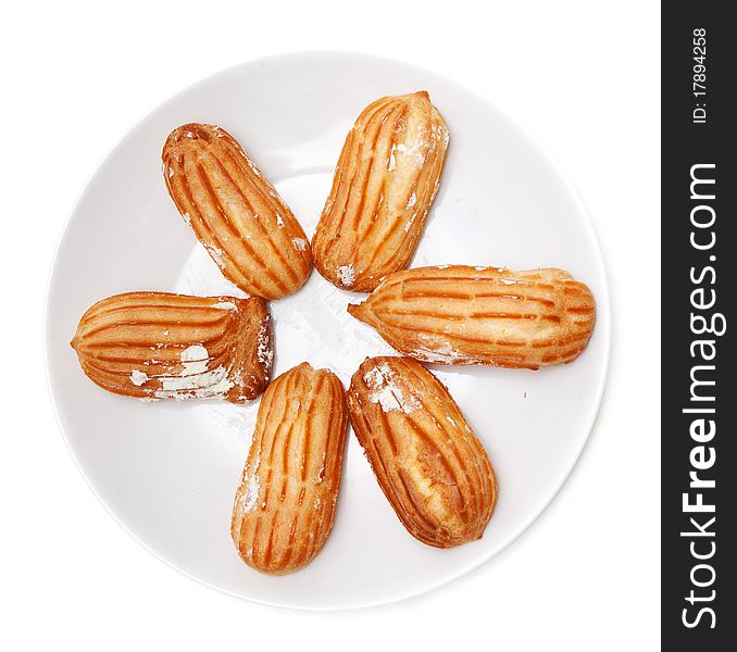 Delicious eclairs arranged on a plate on a white background