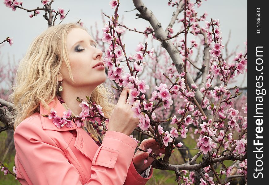 Beautiful blonde girl in spring peach garden. Beautiful blonde girl in spring peach garden