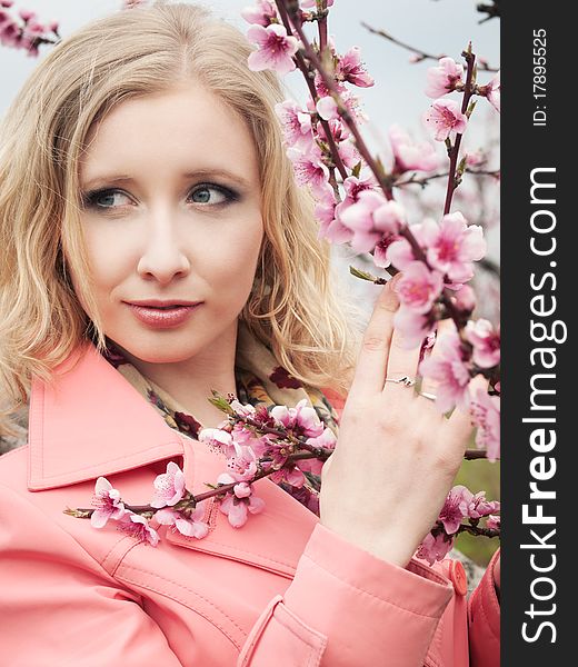 Beautiful blonde girl in spring peach garden. Beautiful blonde girl in spring peach garden