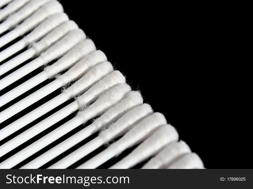 White cotton buds placed diagonally isolated on black background. White cotton buds placed diagonally isolated on black background