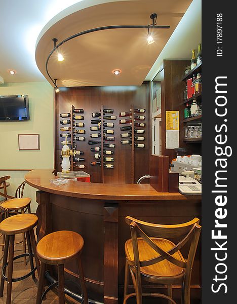 Interior of a small cafe, view on a wooden bar. Interior of a small cafe, view on a wooden bar.