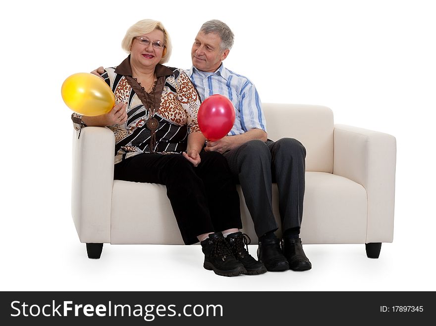 Mature couple sitting on a sofa on a white background