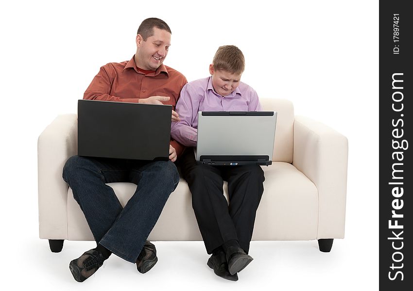 Father and son sitting on the couch with laptops