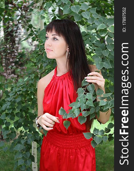 Outdoor portrait of the brunette girl in red