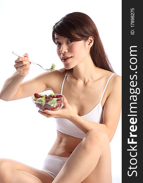 Beautiful woman in underwear eating healthy fruit