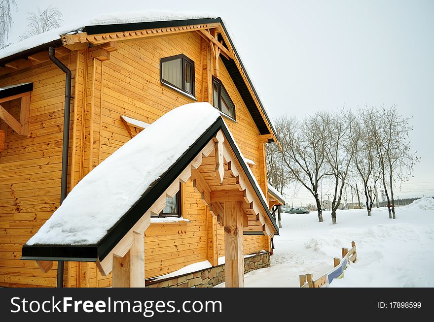 Traditional suburban house, comfortable and warm in winter, residential structure, building exterior, non-urban scene, residential districtstained wood and double windows secure, surrounded by deep snow, pleasant yellow and brown colors. Traditional suburban house, comfortable and warm in winter, residential structure, building exterior, non-urban scene, residential districtstained wood and double windows secure, surrounded by deep snow, pleasant yellow and brown colors