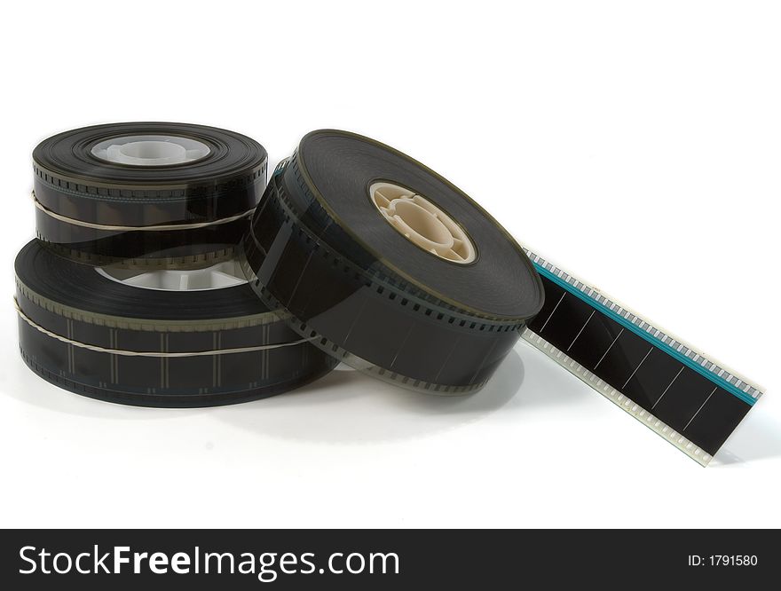 A stack of three 35mm movie film trailers with one unravelling - on white. A stack of three 35mm movie film trailers with one unravelling - on white