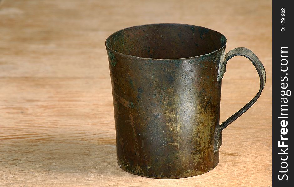 Old  cup from a copper  on a table