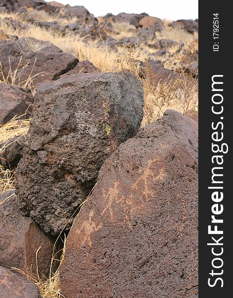 Petroglyph of three figures on volcanic rock