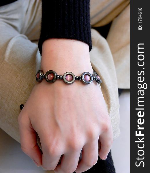 Young girl is hocking on the floor and shows her new bracelet.