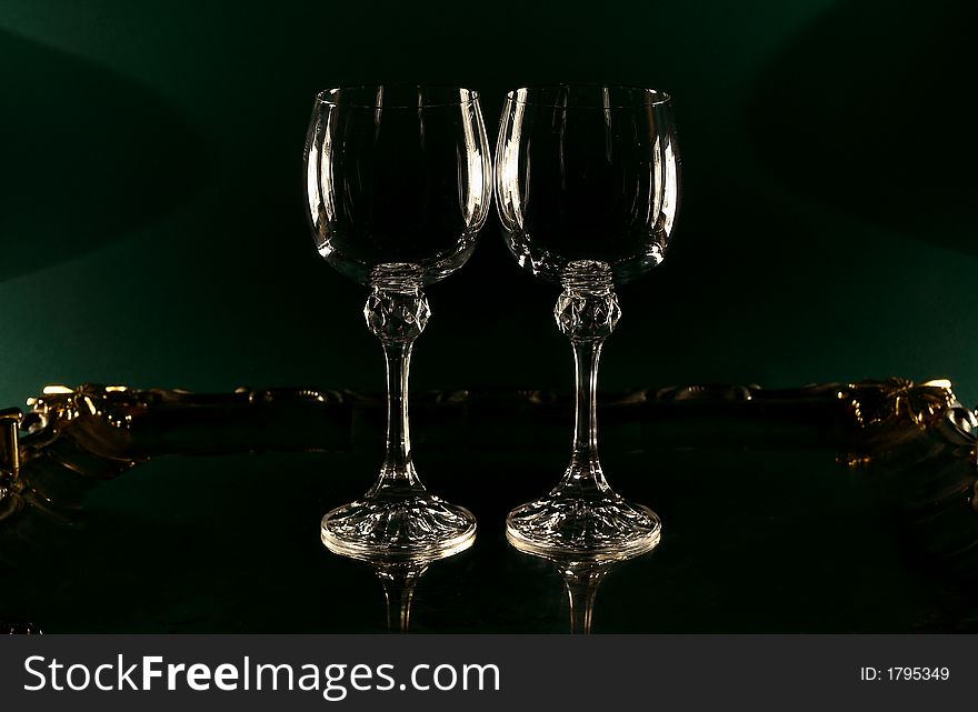 Two wine glasses on a green background, two 300 Watt halogen lamps on both sides. Two wine glasses on a green background, two 300 Watt halogen lamps on both sides
