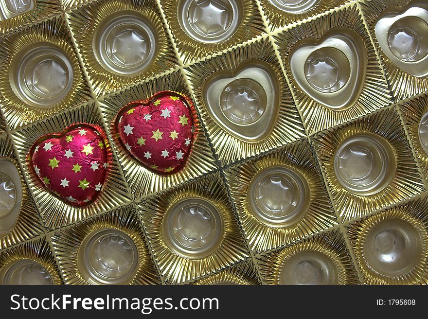 Box with two chocolate candies in shape of heart, a valentine's day gift. Copyspace provided.