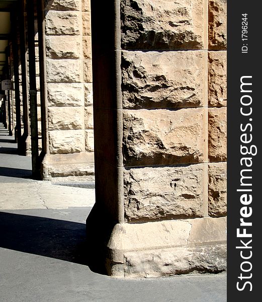 A row of weathered stone pillars in the bright sun