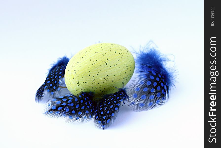 Grenn speckled easter-egg with blue feathers. Grenn speckled easter-egg with blue feathers