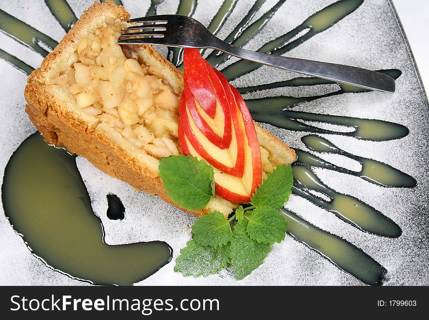 Piece of apple-pie decorated apple slices and coco icing