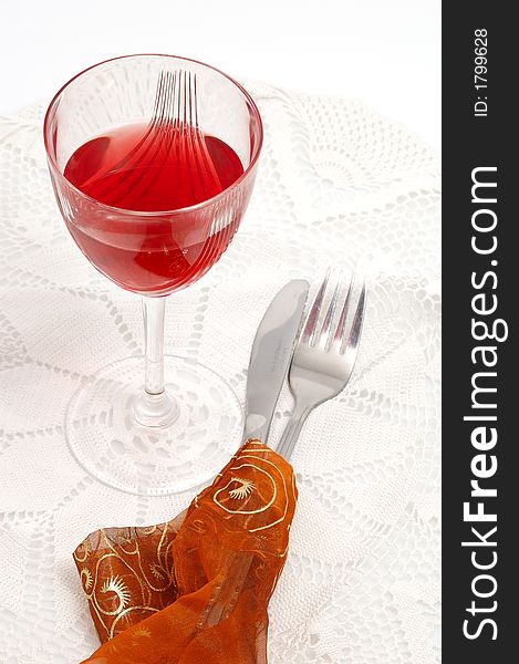 Red glass of wine with fork and knife