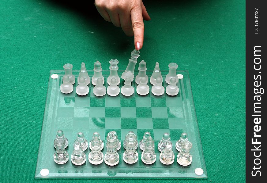 A female hand throwing down the king on a chess match. A female hand throwing down the king on a chess match.