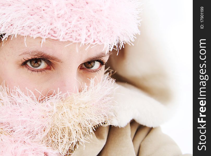 Portrait of pretty woman with face covered by scarf and hat outside in the snow. Portrait of pretty woman with face covered by scarf and hat outside in the snow