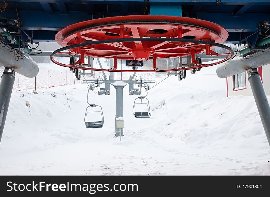 Ski lift equipment that is transporting skiers up to the hills.