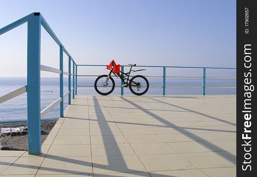 Alone Bicycle At The Seafront Fence In Sunny Day