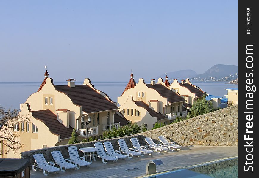 Mansions with tiled roof at Black Sea shore in Crimea Ukraine against mountain seascape