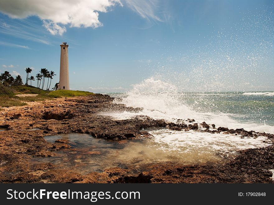 Wave crashing into rocky coast, Barber's Point Lighthouse in the distance. Oahu Hawaii, 2009. Wave crashing into rocky coast, Barber's Point Lighthouse in the distance. Oahu Hawaii, 2009.