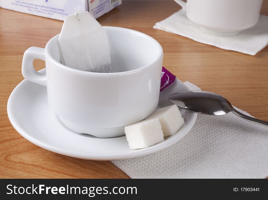 Cup for tea, sugar and spoon on table