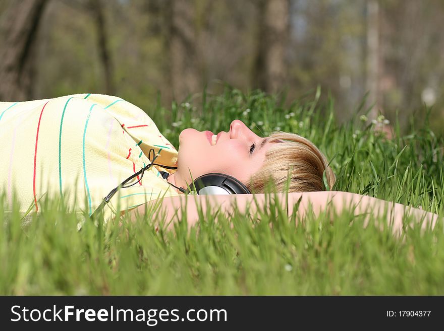 Beautiful young girl with headphones, listen to music on meadow. Beautiful young girl with headphones, listen to music on meadow