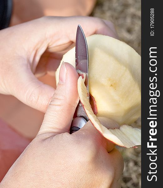 Peeling an apple with a knife.