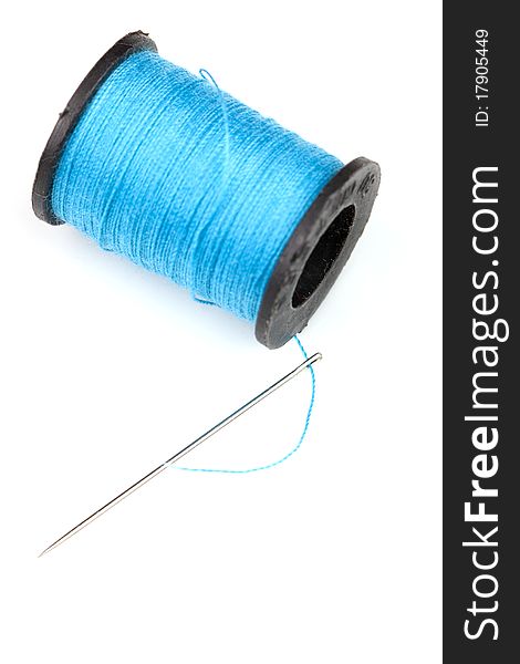 Spool of blue threat and needle isolated on white. Spool of blue threat and needle isolated on white