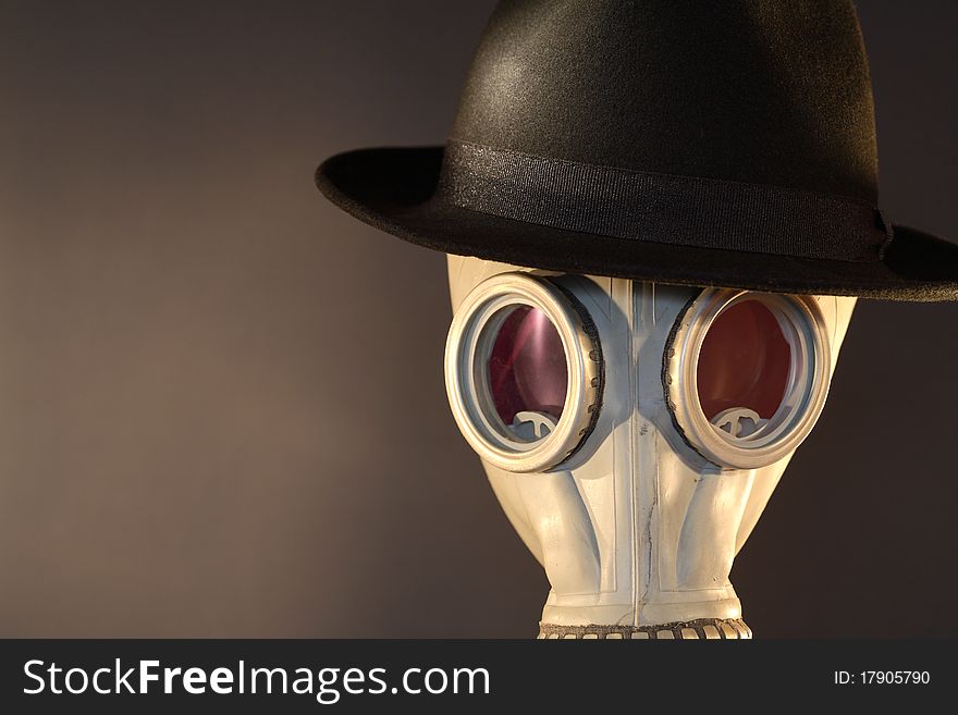 Gas mask with a felt hat closeup on dark background. Gas mask with a felt hat closeup on dark background