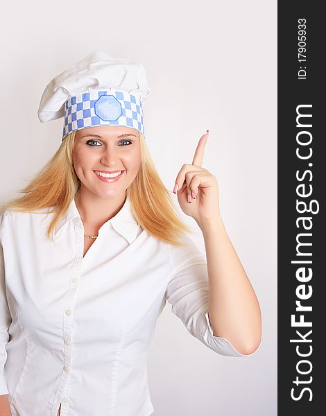 Smiling female chef in full uniform holding her hand. Smiling female chef in full uniform holding her hand