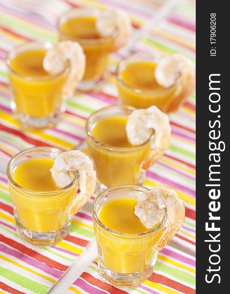 Party snack. Pumpkin soup with orange juice in the glasses and grilled tiger prawns. Party snack. Pumpkin soup with orange juice in the glasses and grilled tiger prawns