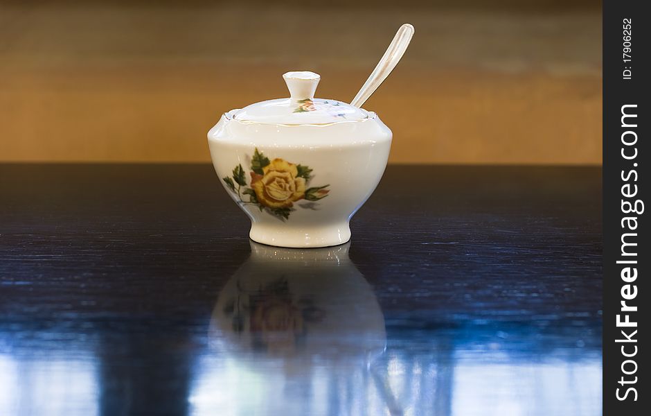 Vintage style Chinese porcelain sugar bowl on table in retro cafe. Vintage style Chinese porcelain sugar bowl on table in retro cafe.