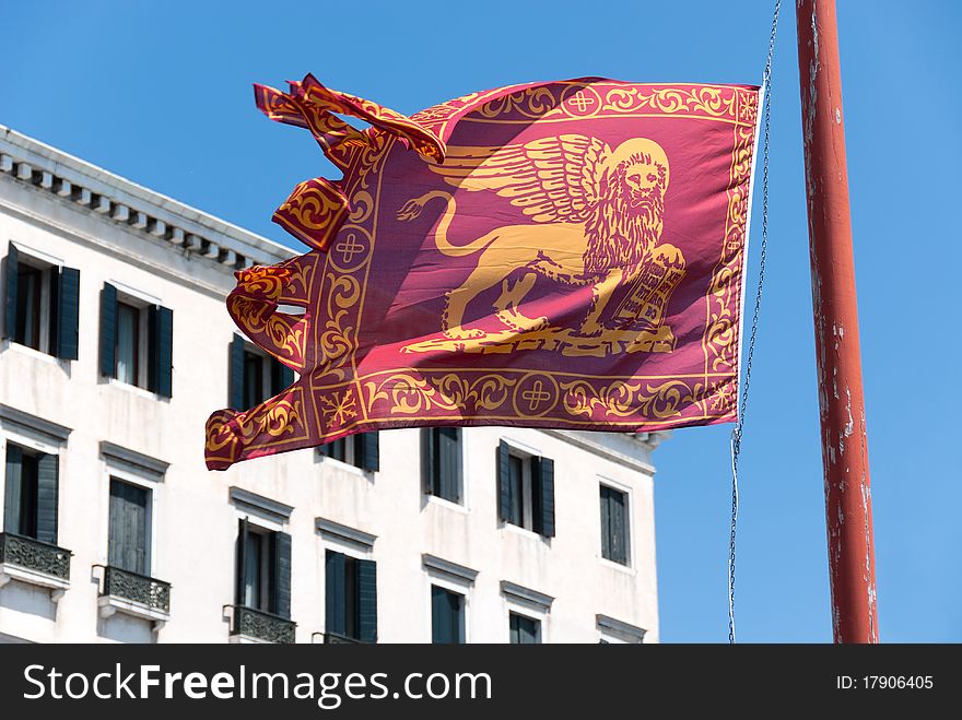 Venetian flag waving under blue sky
