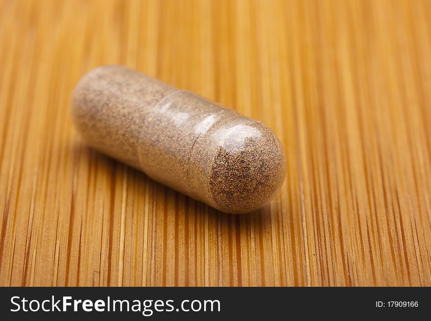 Medical pill against diseases on a wooden table.