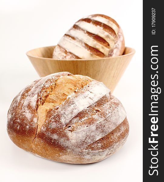 Fresh bread in the foreground and another in a bowl