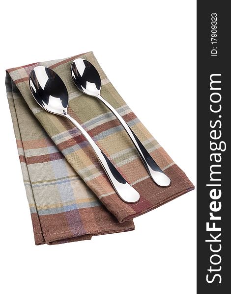 Two spoons on a checkered cloth, tissue.