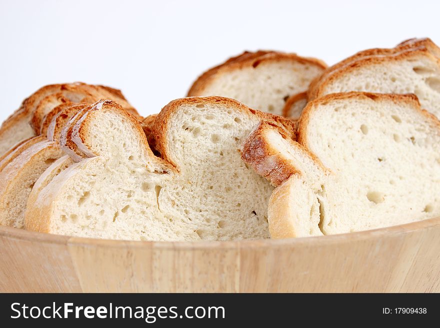 Chopped fresh bread in wooden bowl on white background