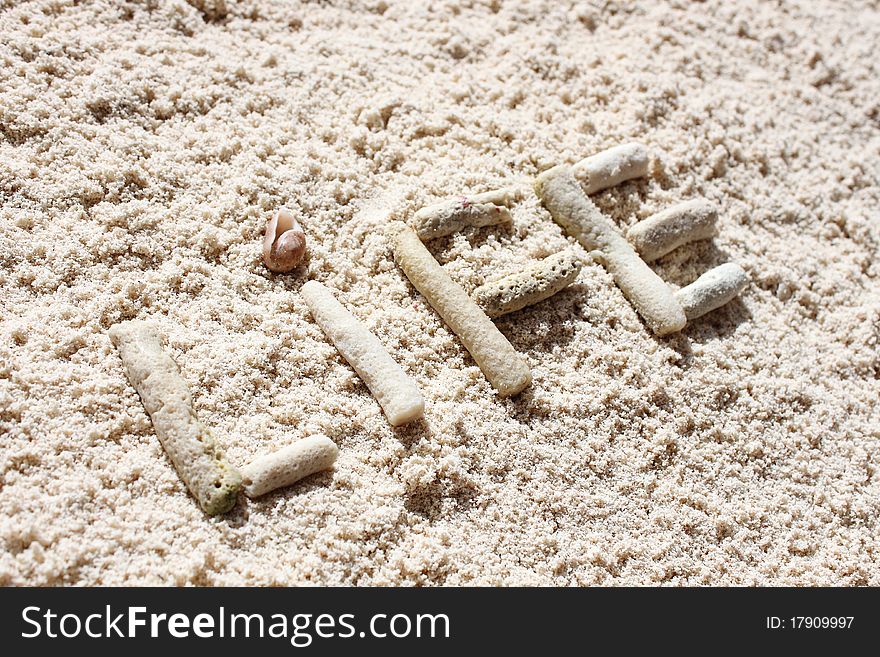 Letters made with sea corals on white sand beach. Letters made with sea corals on white sand beach