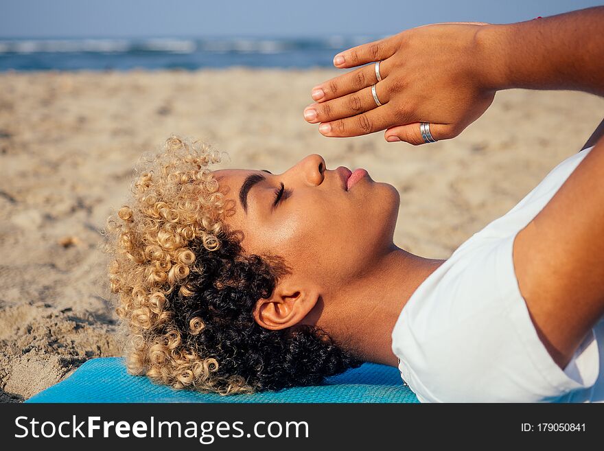 Brazilian hispanic woman training yoga on the beach .