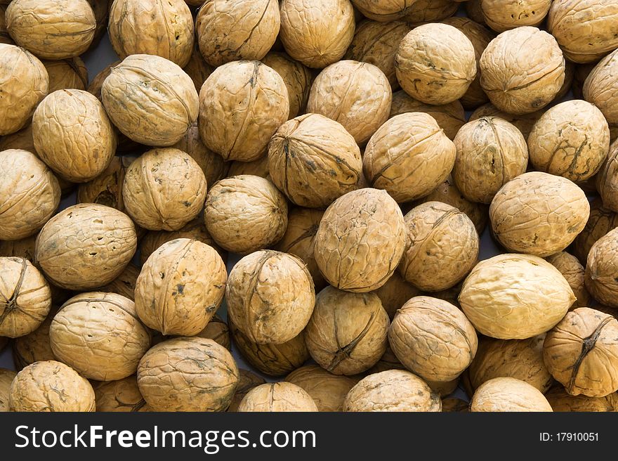 Closeup of brown raw walnuts background