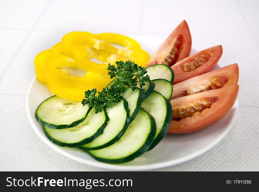 Colored raw vegetables for salad in plate on a table