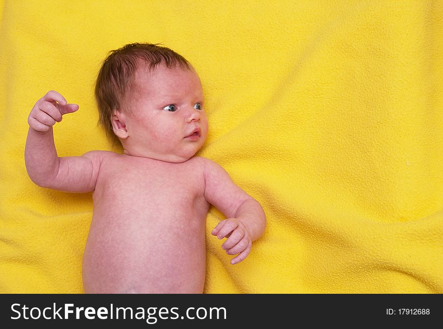 Newborn baby girl over soft yellow towel